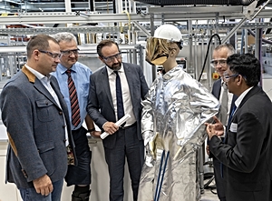 Foto: Prof. Ajay B. Patil - Abteilungsleiter Prozessmetallurgie am HIF erläutert die benötigte Schutzkleidung zur Arbeit am Plasmaofen (v.l.n.r.: Prof. Tobias Fieback - Prorektor Forschung TU Bergakademie Freiberg, Prof. Sebastian M. Schmidt - Wissenschaftlicher Vorstand HZDR, Wissenschaftsminister Sebastian Gemkow, Prof. Jens Gutzmer - Institutsdirektor HIF, Prof. Ajay B. Patil) ©Copyright: HZDR/Detlev Müller